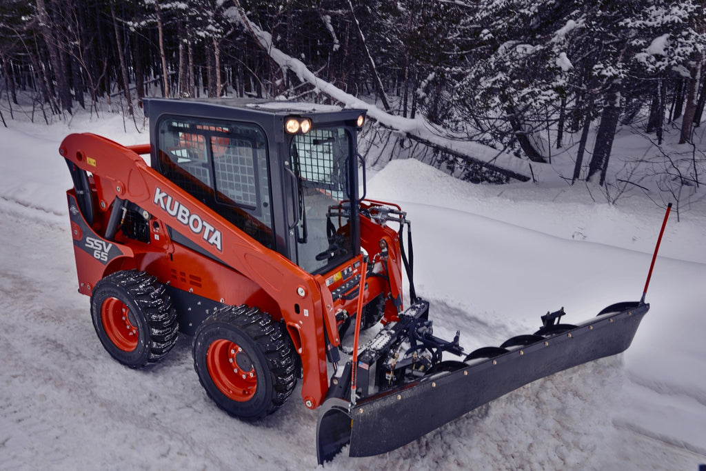 Kubota SSV 65 Shown with a plow for winter sidewalk and parking lot clean ups