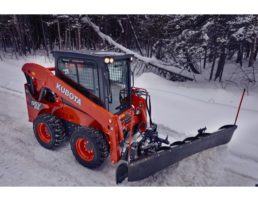 Kubota SSV 65 Shown with a plow for winter sidewalk and parking lot clean ups